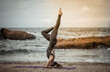 Healthy yogi woman practices headstand on seaside beach. Healthy lifestyle, yoga asana