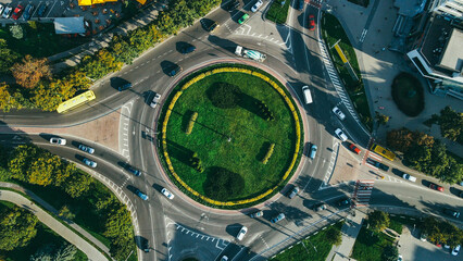 Top view of traffic and people, cars and buses at rush hour at circular junction