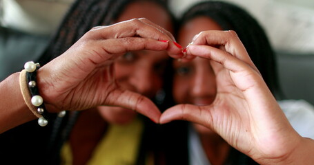 Wall Mural - People doing heart symbol with hands. African black ethnicity, love and caring concept