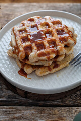 Sticker - Waffles with caramel sauce. Wooden background. Top view. 