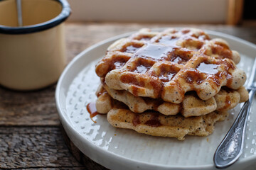 Sticker - Waffles with caramel sauce. Wooden background. Top view. 