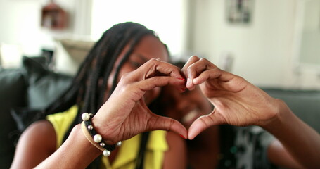 Wall Mural - Mother and daughter making heart symbol with hands. Black African ethnicity