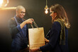 © Thurstan H/peopleimages.com - Keeping his customers smiling. Cropped shot of a cashier passing on a shopping bag to a customer.