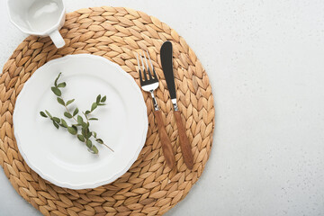 Wall Mural - Vintage zero waste silverware. Rustic vintage set of white plate, wooden spoon and fork on napkin for dishes from water hyacinth on light gray concrete background. Empty dishes. Top view. Mock up.