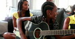 Casual black African family bonding thogether through music guitar. Daughter playing musical instrument