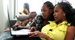 © Marco - Candid African family at home using technology, casual authentic real life black teen girl and mother in front of laptop computer