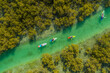 © AmazingAerialAgency - Aerial view of people doing kayak in a small river off Abu Dhabi, United Arab Emirates.