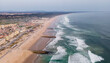 © AmazingAerialAgency - Aerial view of Costa da Caparica landscape at sunset, view of the majestic beach with rough Atlantic Ocean rolling on the shoreline, Setubal, Portugal.