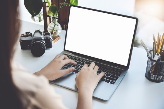 Young woman using work from home computer to avoid the risk of contracting coronavirus in the company at work, the blank space on the computer screen can insert text.