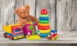© BillionPhotos.com - Cute kid toys. Container with bear, blocks on light background. Cute toys collection for small children. Donation.