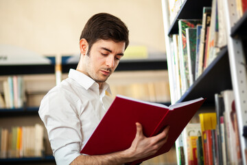 Wall Mural - Student reading a book in a library