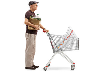 Wall Mural - Full length profile shot of a senior with a paper bag and a shopping cart with a bar chart diagram