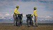 The man and woman travel on mixed terrain cycle touring with bikepacking. The love couple journey with tent in nature with bicycle bags. Stylish bikepacking, bike, sportswear in green black colors.