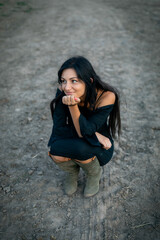 Wall Mural - Girl with long black hair in the countryside. Ipadrome with horses. Rural landscapes, wild west.