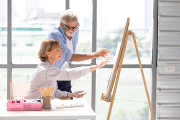 Wall Mural - senior couple painting a picture from paintbrush in free time