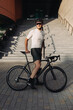 © Tymoshchuk - Caucasian cyclist standing with sport bike at urban area