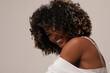 © face_reader_img - Side view of joyful woman with afro hair smiling over white background.