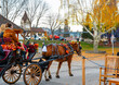 Two women ride a horse drawn carriage through the main street of the Bavarian themed village of Leavenworth, Washington, USA.