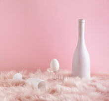 Easter Composition With Egg, Champagne Bottle And White Glass On Pastel Pink Fur Background. Modern Aesthetic. Happy Easter Holiday.