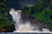 Murchison Falls, Waterfall Between Lake Kyoga And Lake Albert On The Victoria Nile In Uganda. Africa River Landscape. Green Forest Vegetation With Water.
