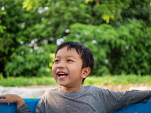 Asian Cute Child Boy Smiling And Laughing With Whitening Teeth In Nature Background With Thinking, Surprised Face In Relaxing Day. Concept Of Healthy Lifestyle, Happy Expression.