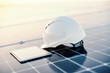 Close up of a helmet and tablet on solar panels.