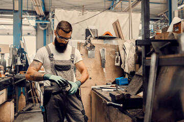 a worker changes disc on grinder at workshop.