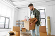 © Syda Productions - moving, people and real estate concept - man holding boxes with stuff at new home