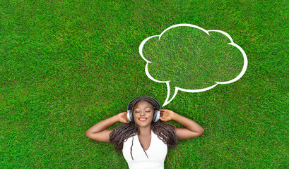 Wall Mural - Pretty smiling girl relaxing outdoor. woman listening to music outside with speech bubble and copy space.