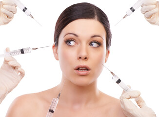 Is this the only way to a wrinkle-free skin. A young woman looking scared while five injection needles point at her face.