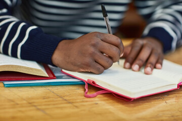 Poster - Taking notes in class. Closeup shot of an unidentifiable university student writing in a book at campus.