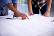 © T Hover/peopleimages.com - Creating great things together. Closeup shot of two young architects working on blueprints in an office.