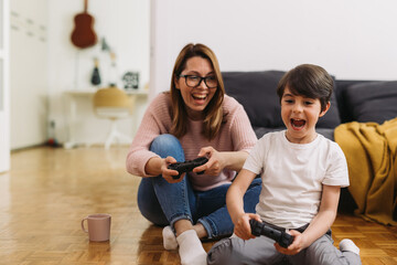 mother and son playing video games at home