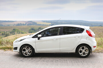 White car against the blue sky side view