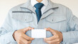 作業服の男性・建設業イメージ｜空白の名刺、ビジネスカードを持つ
