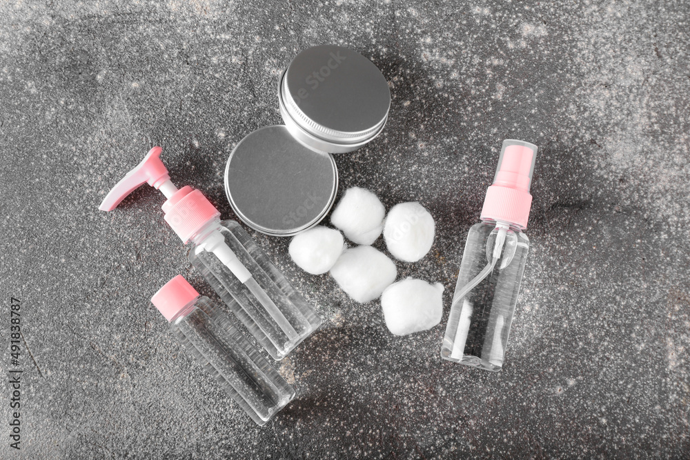 Cosmetic products and cotton balls on grunge background
