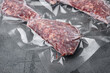Beef patties in a vacuum packing set, on gray stone table background, with copy space for text