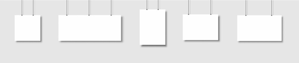 Poster - Template of white blank vector posters. Set of mockups hanging on the wall. Frame for paper sheet. Isolated on gray background. Vector illustration