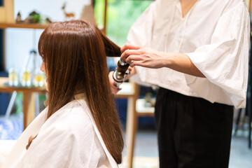 ヘアアイロンを使う美容師