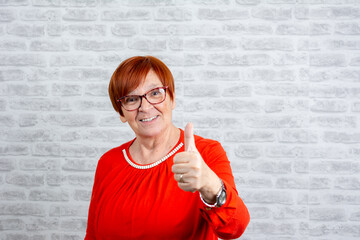 Wall Mural - Happy senior woman with thump up