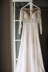 Wall Mural - A beautiful white lace dress for the bride hangs on the door of the hotel