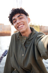 young teenager taking a selfie with smartphone in a city park