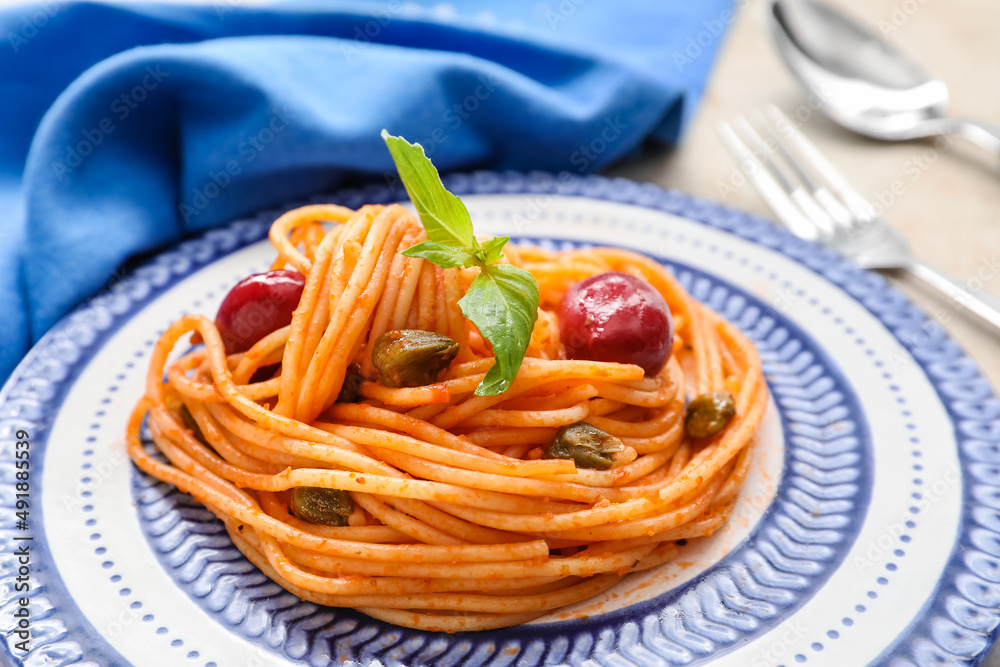 Plate with delicious Pasta Puttanesca on table, closeup