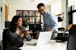 © JustLife - Colleagues in office. Businesswoman and businessman discussing work in office