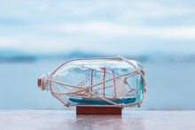 Nautical Concept Image With Sail Boat In The Bottle On The Beach Background