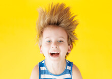 Happy Child Shouting Against Yellow Paper Background