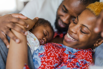 Young parents with their baby girl at home
