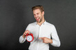 © be free - Happy crazy guy sticking tongue while pointing finger at alarm clock dark background, timing