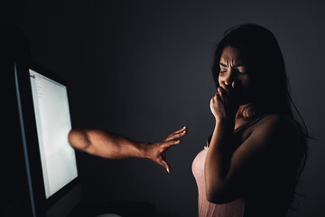 Leinwandbilder - It hurts both whether youre bullied face-to-face or via cyberspace. Shot of a hand extending from a computer screen towards young woman.