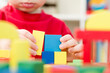 © Birute - A young builder. kid building city from wooden blocks. Kids Play Room. Development and Construction Concept. Toy to learn stimulates imagination, creativity, hand-eye coordination.